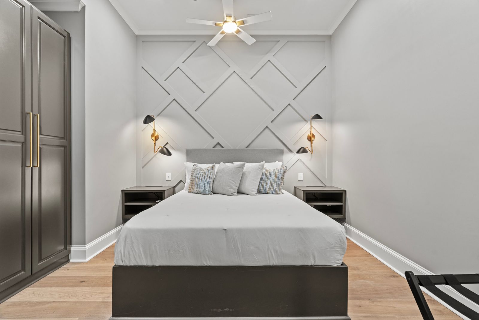 Aurelia Suite bedroom with geometric accent wall and gold sconces
