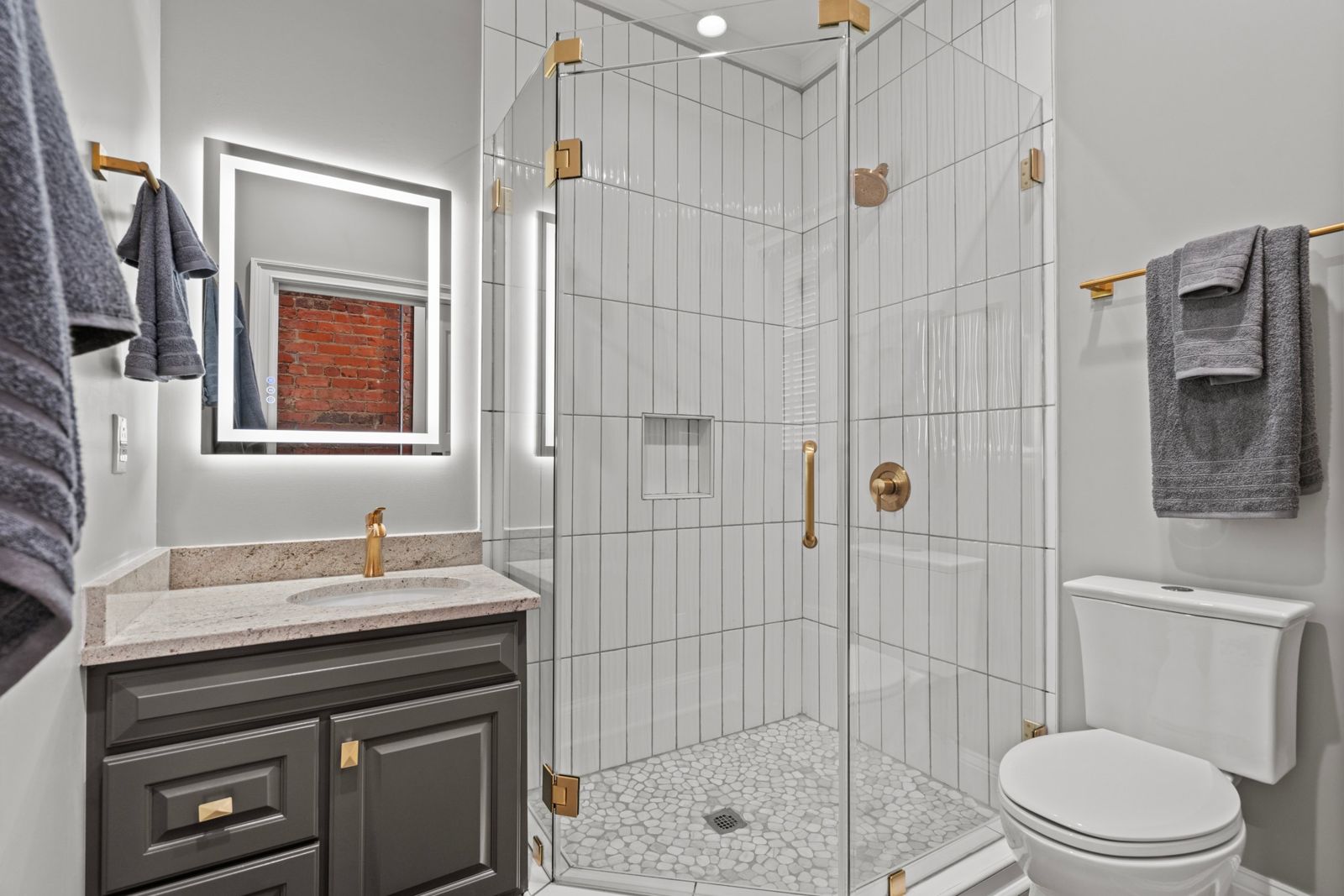 Aurelia Suite bathroom with glass shower and gold fixtures
